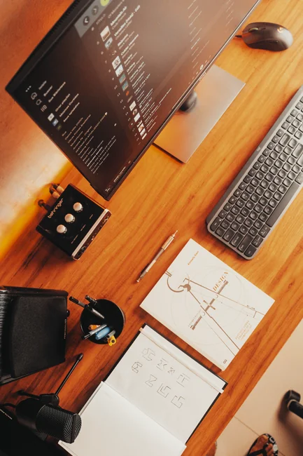 A sleek work area with a laptop and dual monitors showing design software.
